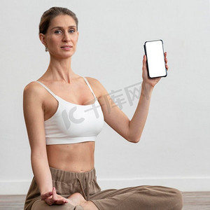 女人家做瑜伽举行智能手机