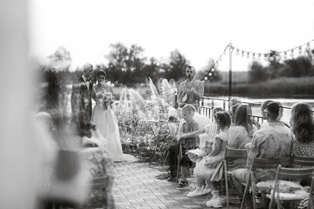 在河边的一个高码头举行婚礼，邀请客人参加