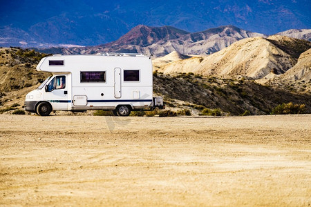 在西班牙阿尔梅里亚的塔贝纳斯沙漠中露营的大篷车。开着摩托之家旅行..西班牙塔贝纳斯沙漠中的露营车