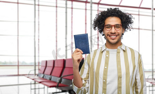 旅行，旅游和文件概念—微笑的人有护照在机场等候室背景。带护照的微笑男子在机场