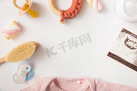 连体框摄影照片_棉花糖粉红色婴儿连体衣刷安抚奶嘴奶瓶玩具白色背景