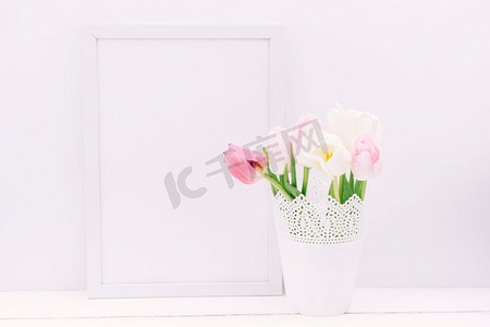 白色鲜花束摄影照片_一种带空框的鲜郁金香花瓶