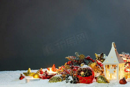 圣诞节假期卡与礼物，球和发光灯笼与蜡烛在雪。圣诞卡与灯笼在雪