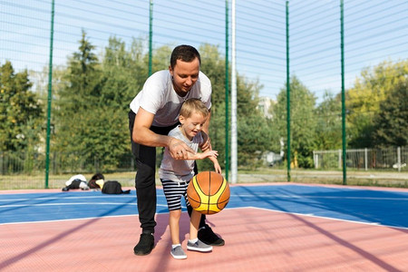 女孩打篮球摄影照片_快乐单亲家庭学习如何打篮球