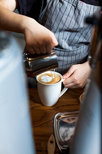 咖啡倒了摄影照片_专业咖啡师倒拿铁泡沫咖啡咖啡馆