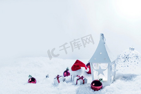 圣诞装饰与蜡烛在灯笼小玩意儿和礼物在雪。圣诞装饰灯笼