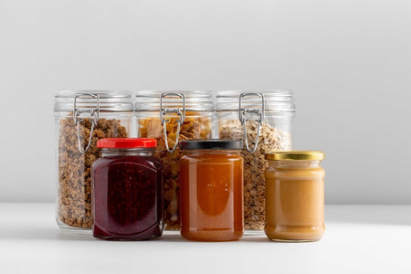 储存食品摄影照片_食物储存，吃和储存概念—近摄蜜饯和谷物在桌子上。近拍的蜜饯和谷物在桌子上