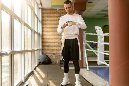一名男子拳击手在拳击场训练前包扎双手