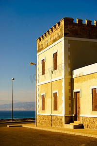 古老的时尚建筑与砖砌起来的窗户，西班牙海岸在背景。西班牙海岸的老建筑