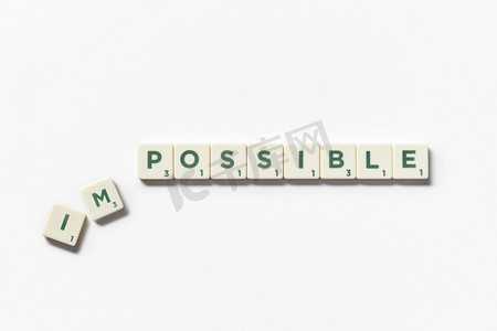 不可能的变成可能的字由拼字游戏块与在白色背景可能形成的拼字游戏块在白色背景。