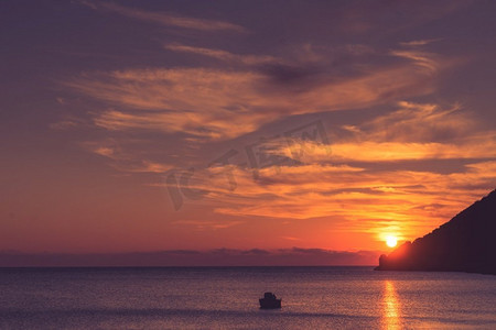 风景日出或日落在海面，船停泊在海湾，希腊。海面上的日出或日落