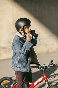 卡通自行车摄影照片_带安全帽的男孩骑自行车