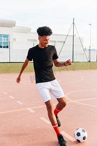 黑人足球运动员跑步踢球运动场
