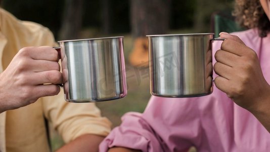 户外野餐摄影照片_一对夫妇在户外露营时喝着热饮