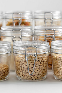食物储存、烹饪和储存概念--桌上有不同谷物或杂货的罐子。桌子上有装有谷类或食品杂货的罐子
