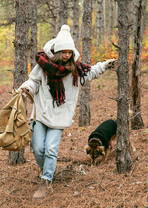 年轻女子冬季衣服与她的狗