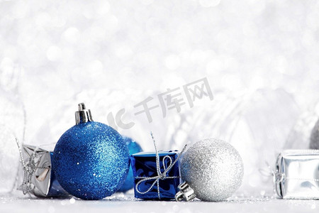 装饰圣诞球和礼物在抽象闪光银背景。圣诞球和礼物
