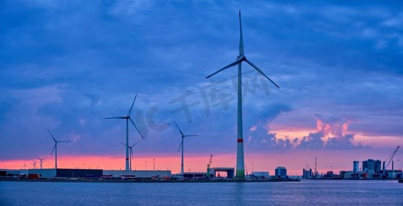 比利时摄影照片_全景风力涡轮机发电机在安特卫普港口在晚上。比利时安特卫普安特卫普港口的风力涡轮机在晚上