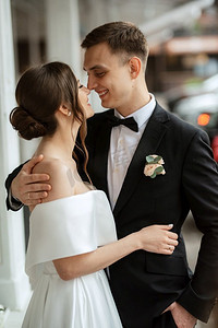 年轻夫妇新娘和新郎在一个白色短礼服走在雨中