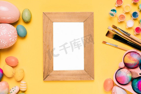 木质空白白色边框，复活节彩蛋画笔，水彩画黄色背景
