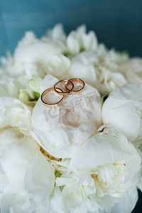 结婚金色摄影照片_红色结婚花束上的金色结婚戒指舔在树皮下