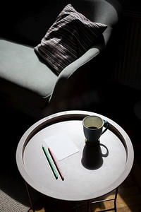 咖啡杯和空白卡在桌子上在严酷的阳光