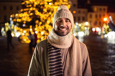 寒假与人们的观念--圣诞城晚间欢乐笑脸人写真。快乐的微笑男人在圣诞城的夜晚