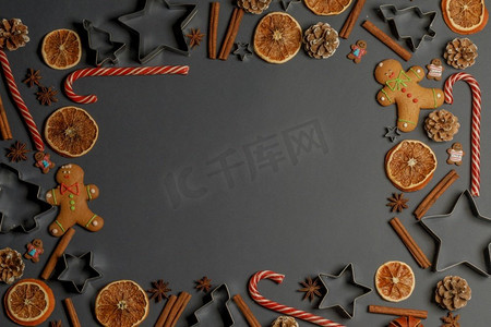 传统边框摄影照片_圣诞食品边框。姜饼饼干，香料和装饰品在深色背景上。圣诞食品界背景。