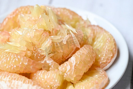 在泰国夏天的热带水果中，把柚子放在白色盘子里，从柚树上剥下新鲜的柚子，柚子，葡萄柚