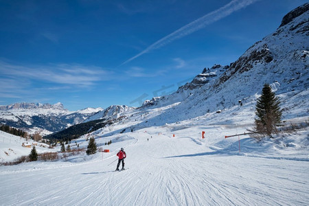 看法摄影照片_一个滑雪胜地滑雪道的看法与人们滑雪在多洛米蒂在意大利。意大利卡纳泽。滑雪胜地在多洛米蒂，意大利