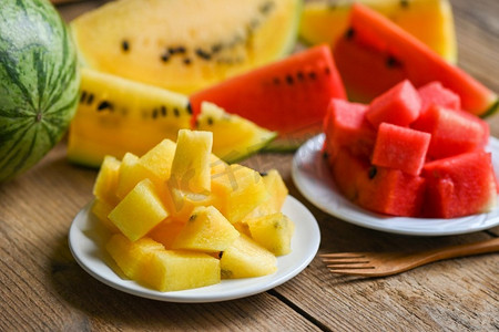 特写镜头甜的西瓜片片新鲜的西瓜热带夏天水果，红色和黄色的西瓜片在盘子和木背景