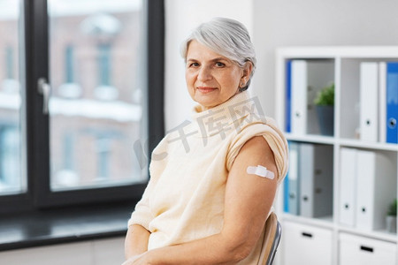 医学、健康和疫苗接种概念—在医院接受了疫苗接种的老年妇女手臂上的医疗贴片。接种疫苗的妇女手臂上有医疗贴片