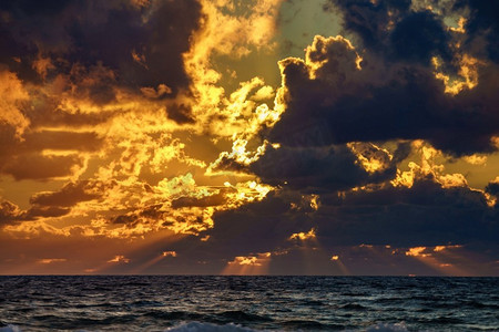 日落，海上的阳光，暴风雨的云。晚上的海边风景。海上的日落，暴风雨的云