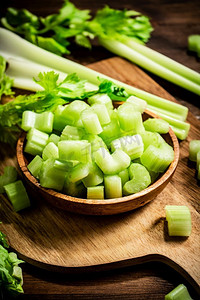 清明芹菜摄影照片_切好的新鲜芹菜放在砧板上。在一个木制的背景。高质量的照片。切好的新鲜芹菜放在砧板上。 