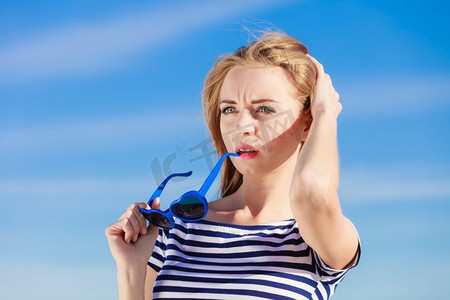 夏日休闲概念..戴着蓝色心形太阳镜的肖像女孩在户外享受夏日的微风