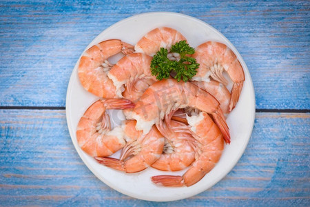 鲜虾在白色盘子，煮熟的去皮虾虾在海鲜餐厅煮—顶视图 