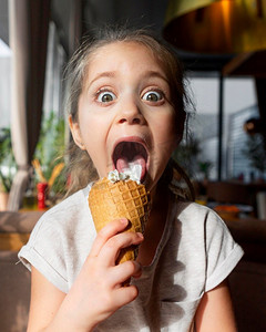 可爱冰淇淋摄影照片_可爱的女孩吃冰淇淋