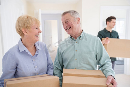 老年夫妇在退休时削减规模携带箱子进入新家搬家日与搬迁男子帮助