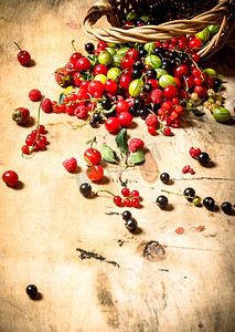 红色一张摄影照片_装满浆果的篮子。在一张木桌上..装满浆果的篮子。在木桌上。