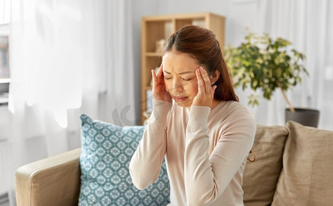 人与健康概念—生病的亚洲妇女在家中头痛。生病的亚洲妇女有头痛在家里
