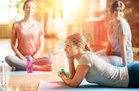 健身、人和健康生活方式概念-瑜伽课上的一群妇女在演播室的垫子上休息。一群妇女在工作室的瑜伽垫上休息