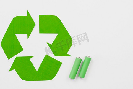 电池回收标志摄影照片_绿色电池旁边的回收标志。高分辨率照片。绿色电池旁边的回收标志。高品质的照片