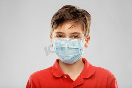 健康防护，安全及流行病概念—戴防护口罩的男童灰色背景。戴防护口罩的男孩