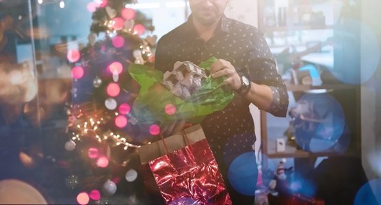 新年启动摄影照片_圣诞节和新年办公室党概念商人打开礼品盒关闭细节与圣诞树在背景