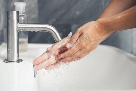 预防新型状病毒摄影照片_洗手以预防新型冠状病毒病2019或COVID—19。人们在洗手池洗手以清除病毒感染。