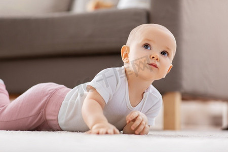 婴儿时代，儿童和人的概念—小女婴爬在家里的地板上。小女婴爬在家里的地板上