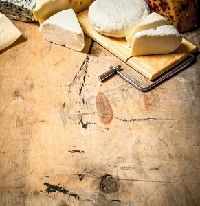 新鲜芳香的奶酪放在特殊的木板上。在一张木桌上..新鲜芳香的奶酪放在特殊的木板上。