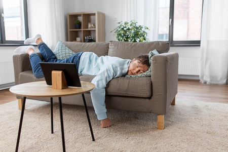 无聊摄影照片_人，无聊和抑郁的概念—懒惰的年轻人睡在家里的沙发上。年轻人睡在沙发上在家里