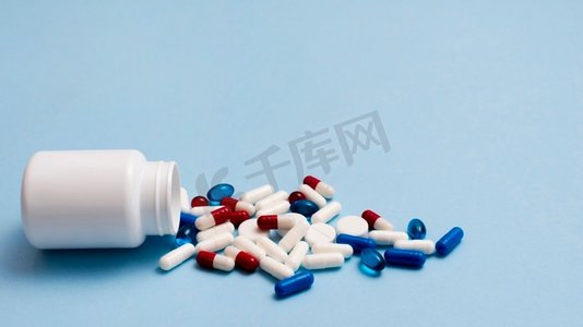药房背景摄影照片_白色药丸容器，蓝色背景。高分辨率照片。白色药丸容器，蓝色背景。高质量照片