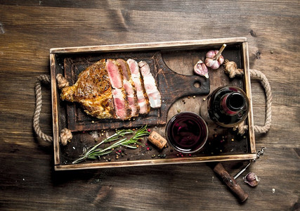 牛肉烧烤配红酒。在一张木桌上..牛肉烧烤配红酒。